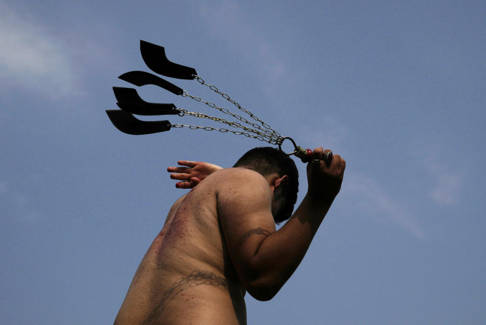 A Shiite Muslim flagellates himself with knifes on chains during a procession to mark Ashoura, in Islamabad, Pakistan, Friday, July 28, 2023. Ashoura is the Shiite Muslim commemoration marking the death of Hussein, the grandson of the Prophet Muhammad, at the Battle of Karbala in present-day Iraq in the 7th century. (AP Photo/Rahmat Gul)