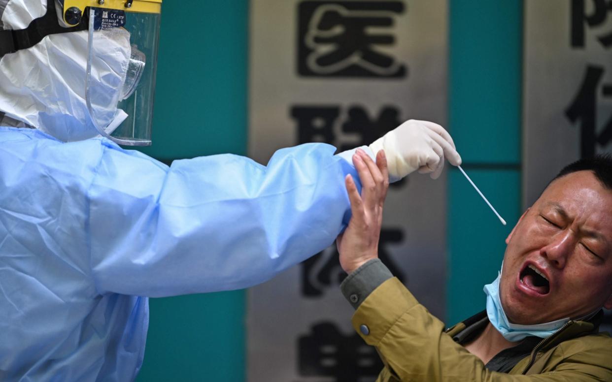  A man being tested for the COVID-19 novel coronavirus reacts as a medical worker takes a swab sample in Wuhan in China's central Hubei province on April 16, 2020. - China has largely brought the coronavirus under control within its borders since the outbreak first emerged in the city of Wuhan late last year. (Photo by Hector RETAMAL / AFP) (Photo by HECTOR RETAMAL/AFP via Getty Images) - AFP