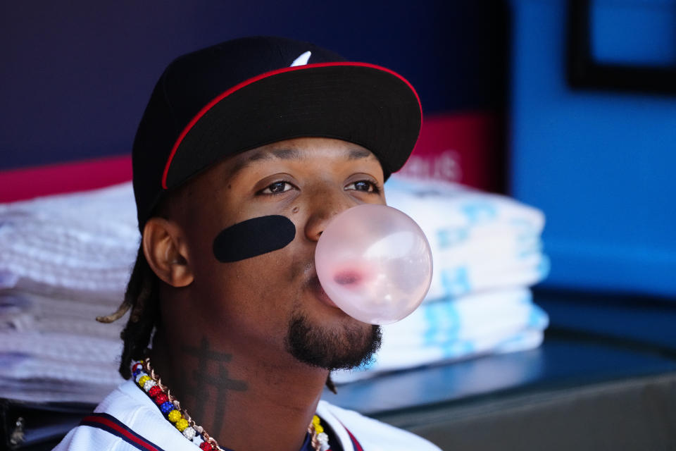 Atlanta Braves' Ronald Acuña Jr. blows a bubble as he waits to take the field for a baseball game against the Arizona Diamondbacks Sunday, April 7, 2024, in Atlanta. (AP Photo/John Bazemore)