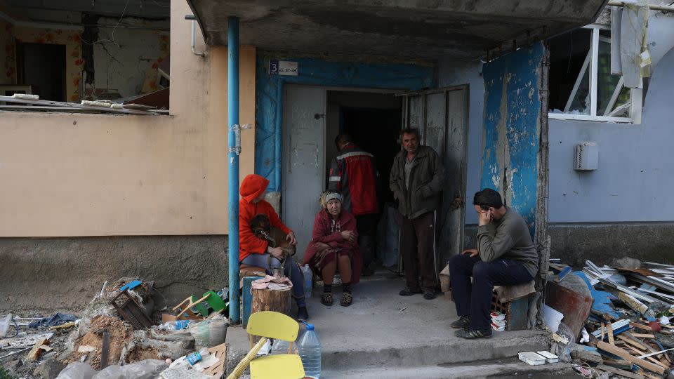 Local residents sit at the entrance of an apartment building destroyed by shelling in Ocheretyne on April 15. - Anatolii Stepanov/AFP/Getty Images