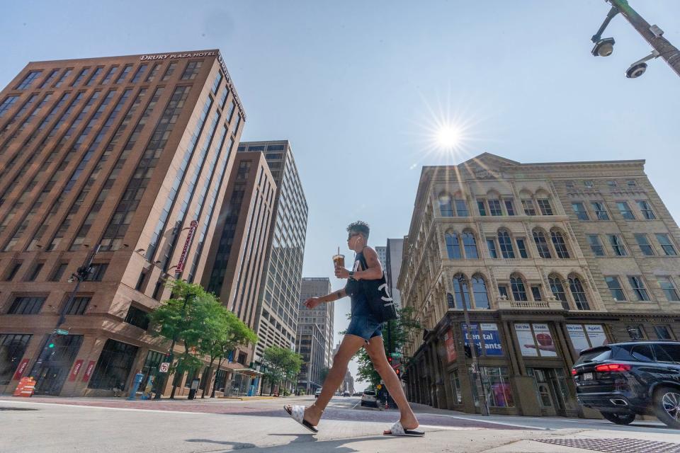 As the sun beats down, Windell Gabrillo, of Milwaukee, working for a courier service, walks along North Water Street at East Wisconsin Avenue en route to deliver a package in Milwaukee on Tuesday, July 25, 2023.