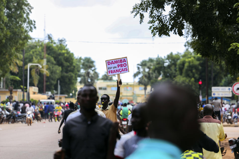 Supporters of Capt. Ibrahim Traore cheer in the streets of Ouagadougou, Burkina Faso, Sunday, Oct. 2, 2022. Burkina Faso's new junta leadership is calling for calm after the French Embassy and other buildings were attacked. (AP Photo/Kilaye Bationo)