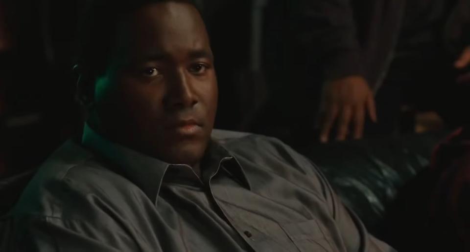 Michael Oher sitting on a couch in "The Blind Side"