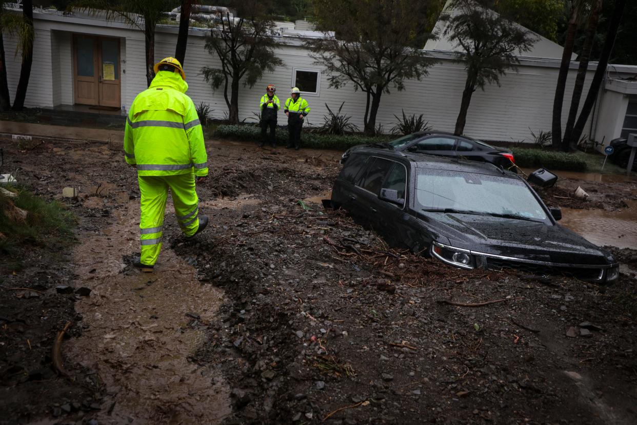 LAPD firefighters respond to a landslide in the neighborhoods above Beverly Hills that caused two vehicles to be trapped in the mud and forced several residents to evacuate on Feb. 5, 2024. A powerful atmospheric river storm deluged California on Monday with more heavy rain, mudslides, flooding and several feet of snow in the mountains.