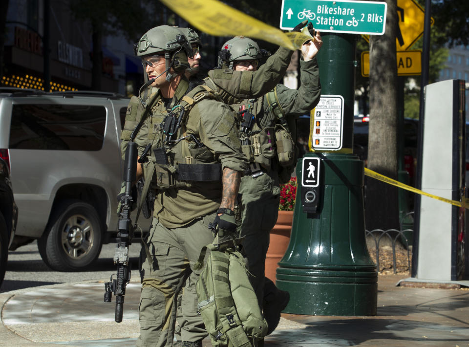 Montgomery police officers in tactical gear exit a parking garage where a police officer was shot, in downtown Silver Spring, Md., Monday, Oct. 14, 2019. Police in Montgomery County, Maryland, said they were searching for at least one person after an officer was found shot in a parking garage in downtown Silver Spring on Monday. (AP Photo/Jose Luis Magana)