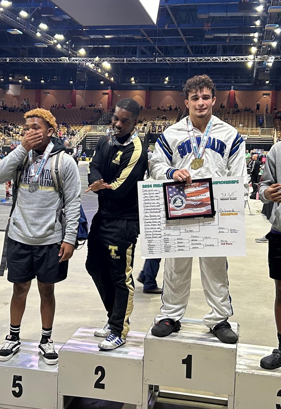 Treasure Coast senior Jabore Brown poses for photos at the podium after placing second in the Class 3A 165-pound weight class at the FHSAA wrestling state championships on Saturday, March 2, 2024 from the Silver Springs Arena in Kissimmee.