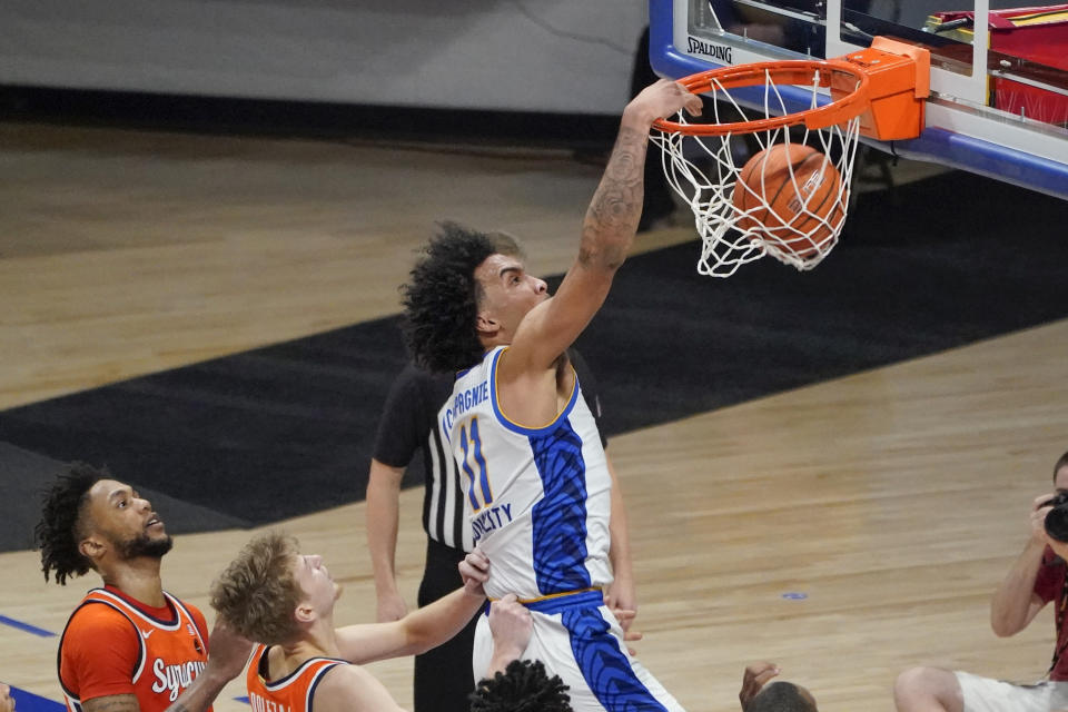 Pittsburgh's Justin Champagnie (11) dunks after getting by Syracuse's Alan Griffin, left, and Marek Dolezaj, center, during the second half of an NCAA college basketball game, Saturday, Jan. 16, 2021, in Pittsburgh. (AP Photo/Keith Srakocic)