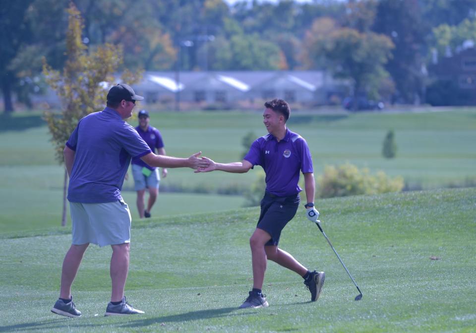 Fort Collins boys golfer Ian Hunn high-fives his coach after he chipped in for eagle on No. 16 to tie for the lead during the Colorado Class 5A state championships at City Park Golf Course in Denver on Tuesday, Oct. 4, 2022.