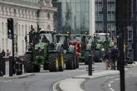 Farmers from the group Save British Farming drive tractors across Westminster Bridge, in London, in a protest against cheaply produced lower standard food being imported from the U.S. after Brexit that will undercut them, Wednesday, July 8, 2020. (AP Photo/Matt Dunham)