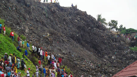 People gather at the site of a mudslide at a rubbish landfill in the Dar Es Salam neighbourhood, on the outskirts of the capital Conakry, Guinea, August 22, 2017. REUTERS/Saliou Samb