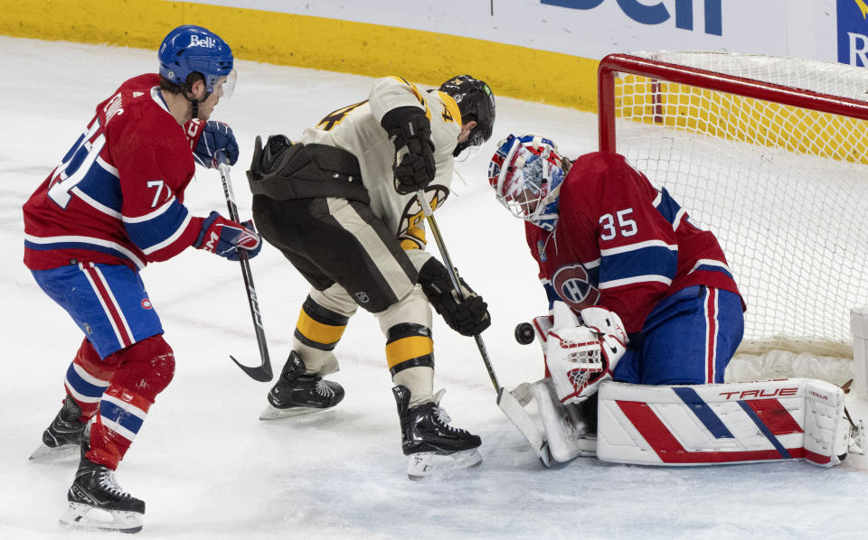 Montreal Canadiens goaltender Sam Montembeault (35) makes a save against Boston Bruins' Jake DeBrusk (74) as Canadiens' Jake Evans (71) defends during third-period NHL hockey game action in Montreal, Thursday, March 14, 2024. (Christinne Muschi/The Canadian Press via AP)