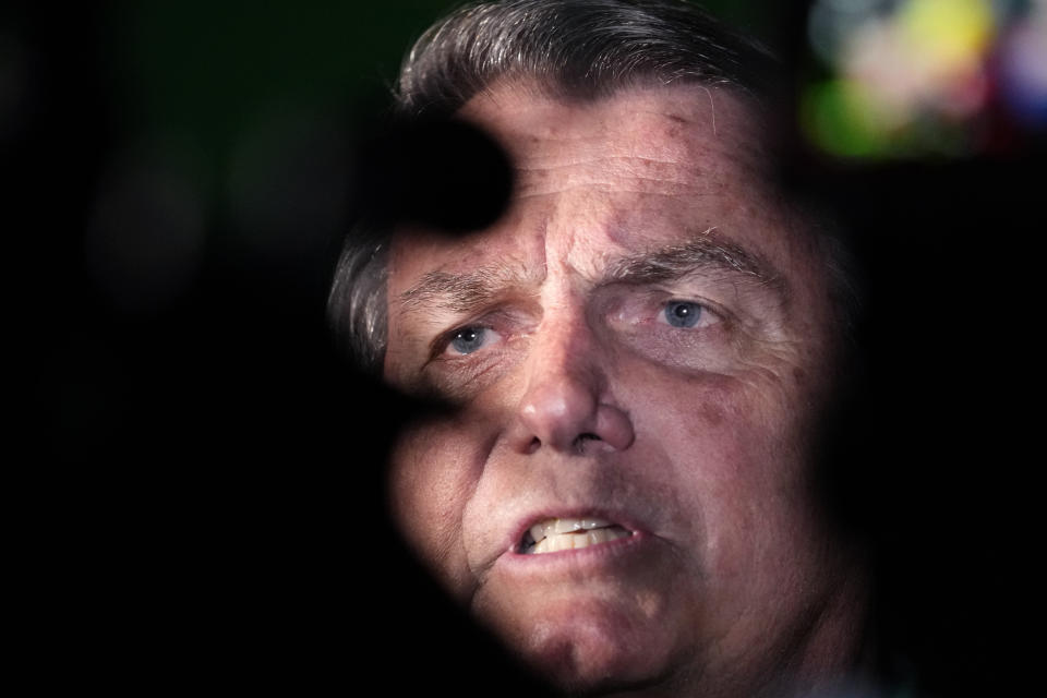 FILE - Former President Jair Bolsonaro talks to reporters after arriving at the airport in Brasilia, Brazil, June 30, 2023. Bolsonaro was barred from running for office again until 2030 after a panel of judges concluded that he abused his power and cast unfounded doubts on the country’s electronic voting system. (AP Photo/Eraldo Peres)