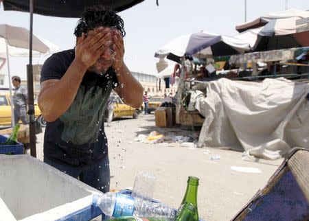 A man washes his face to cool off during a warm summer day in Baghdad, in this file photo taken July 30, 2015. REUTERS/Ahmed Saad/Files