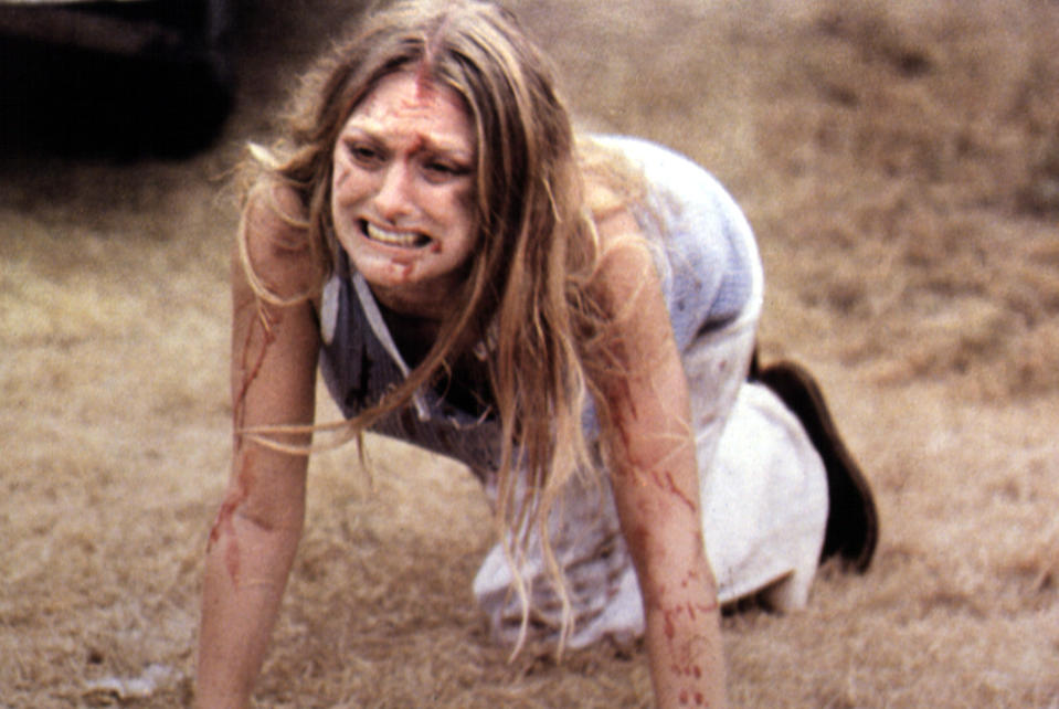 Marilyn Burns crawls on the ground bloody