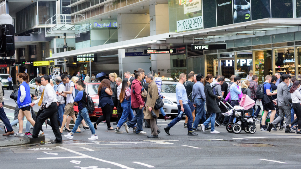 People cross a busy street at Sydney's Pitt Street mall.