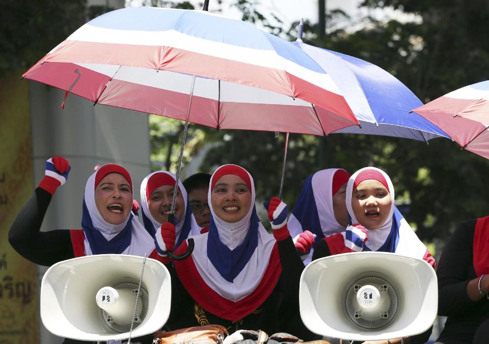 Anti-government protesters sing a song as they ride on a truck during a rally Thursday, May 8, 2014 in Bangkok, Thailand. A court ousted Thailand's prime minister Yingluck Shinawatra for abuse of power, accomplishing what anti-government demonstrators have sought to do for the past six months and further widening the country's sharp political divide. (AP Photo/Apichart Weerawong)