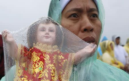 A nun prays as he holds a statue of baby Jesus before a Mass led by Pope Francis at Rizal Park in Manila January 18, 2015. REUTERS/Erik De Castro