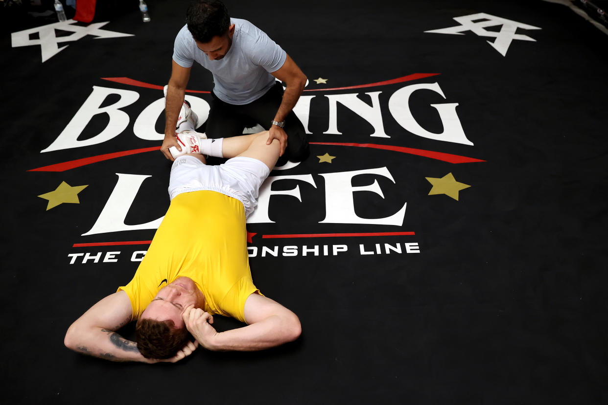 El preparador físico Munir Somoya ayuda al boxeador mexicano Saúl 'Canelo' Álvarez a estirarse durante un entrenamiento en abril de 2021. (Foto: Sean M. Haffey/Getty Images)