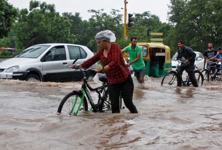 People commute through a flooded road after heavy rains in Chandigarh, India, June 28, 2016. REUTERS/Ajay Verma