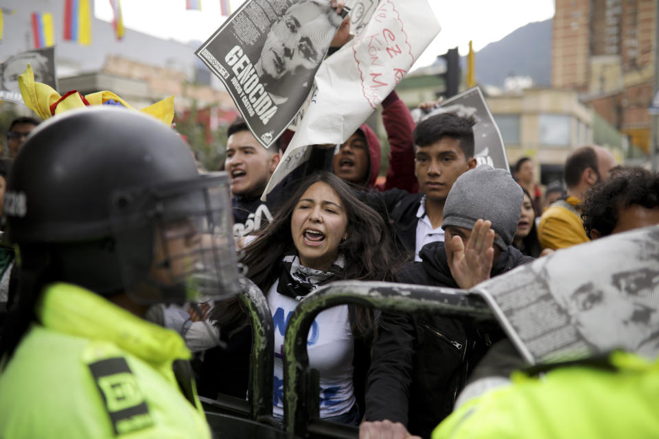 Opponents of former President Alvaro Uribe rally in front of the Supreme Court during his hearing in an investigation for witness tampering charges, in Bogota, Colombia, Tuesday, Oct. 8, 2019. Uribe is under investigation by the Supreme Court over allegations he made false accusations and tried to influence members of a former paramilitary group in a case he had started by accusing leftist Sen. Ivan Cepeda of plotting to falsely tie him to right-wing paramilitary groups. (AP Photo/Ivan Valencia)