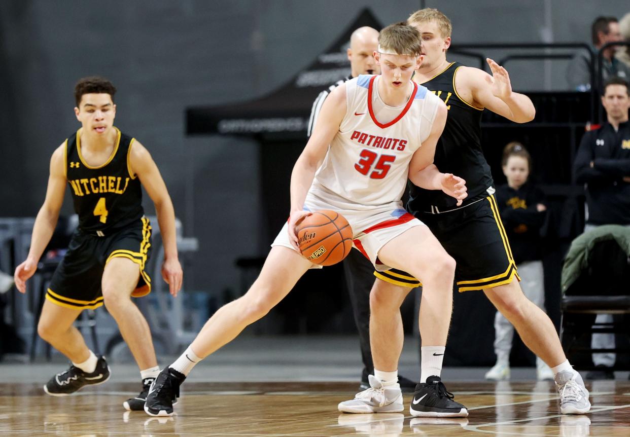 Sioux Falls Lincoln's JT Rock (35) handles the ball against Mitchell's Charlie McCardle during their semifinal game in the state Class AA boys basketball tournament on Friday, March 17, 2023 in The Monument at Rapid City.