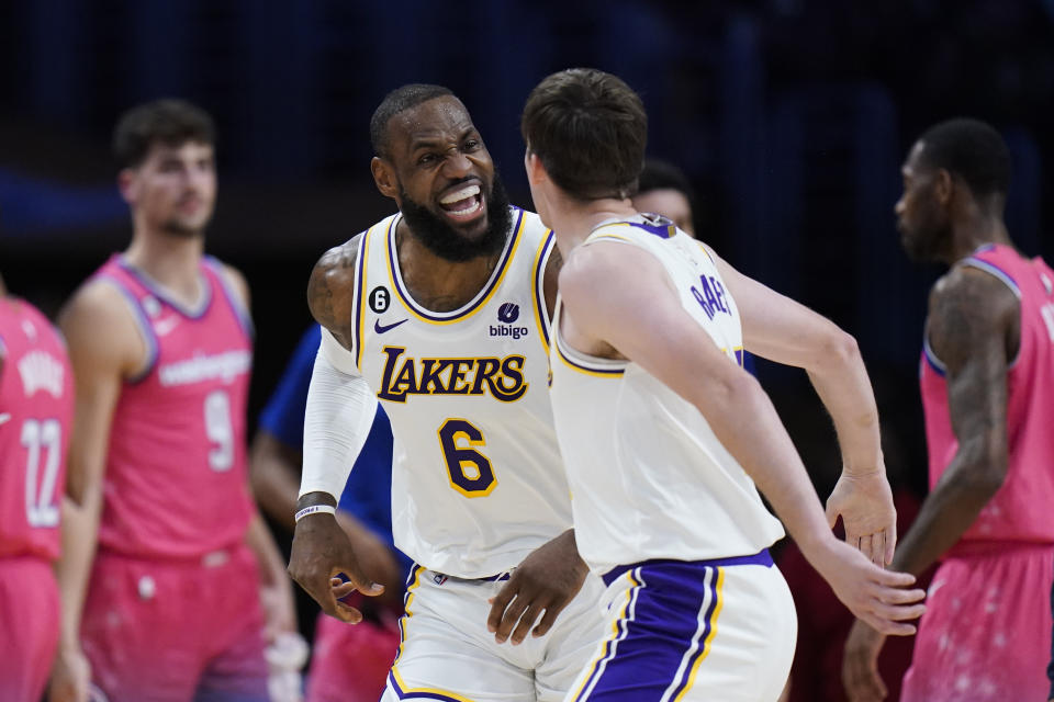 Los Angeles Lakers' LeBron James (6) celebrates with Austin Reaves (15) after making a basket assisted by Reaves during first half of an NBA basketball game against the Washington Wizards, Sunday, Dec. 18, 2022, in Los Angeles. (AP Photo/Jae C. Hong)