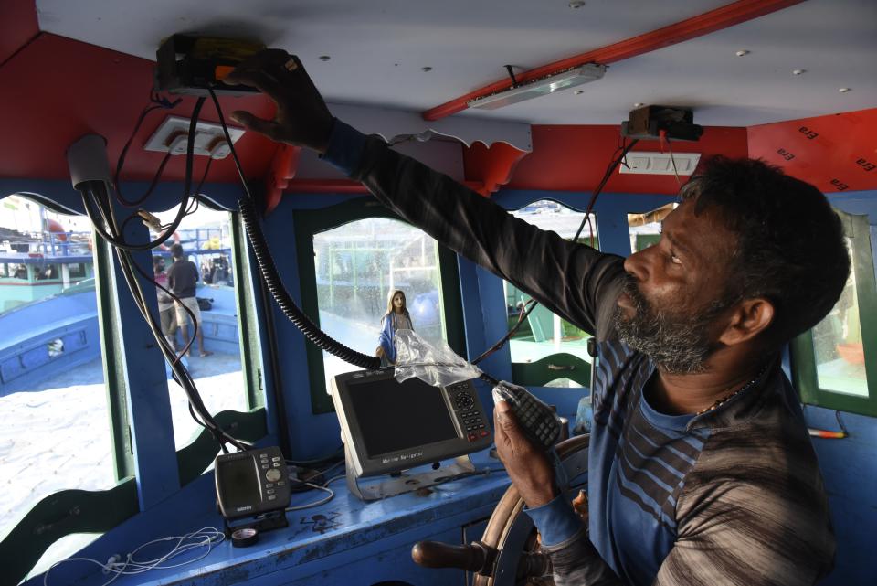 Fisherman Jerome Beji adjusts the radio system on a boat on March 3, 2023, in Kochi, Kerala state, India. The India Meteorological Department as well as the state of Kerala have increased infrastructure for cyclone warnings since Cyclone Ockhi in 2017, which killed about 245 fishermen out at sea. (AP Photo/Satheesh AS)