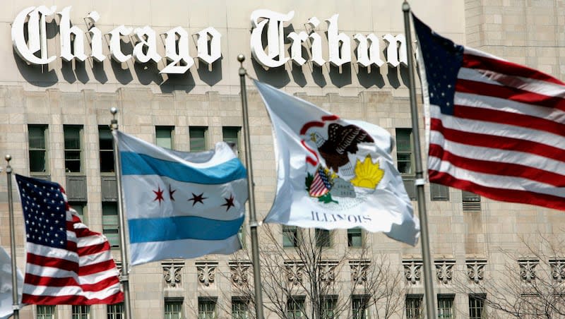 In this April 12, 2006, file photo, flags wave near the Chicago Tribune Tower in downtown Chicago. A group of eight U.S. newspaper publishers, including the Chicago Tribune, filed a lawsuit in New York federal court on Tuesday, April 30, 2024, claiming Microsoft and artificial intelligence developer OpenAI broke copyright law by using the newspapers’ online content to develop AI tools.