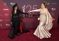 Spotlight Award honoree Angela Bassett, left, a cast member in "Black Panther: Wakanda Forever," joins hands with the film's costume designer Ruth E. Carter at the 25th Costume Designers Guild Awards, Monday, Feb. 27, 2023, in Los Angeles. (AP Photo/Chris Pizzello)