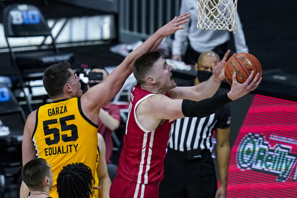 Wisconsin forward Micah Potter (11) shoots next to Iowa center Luka Garza (55) during the second half of an NCAA college basketball game at the Big Ten Conference men's tournament in Indianapolis, Friday, March 12, 2021. (AP Photo/Michael Conroy)