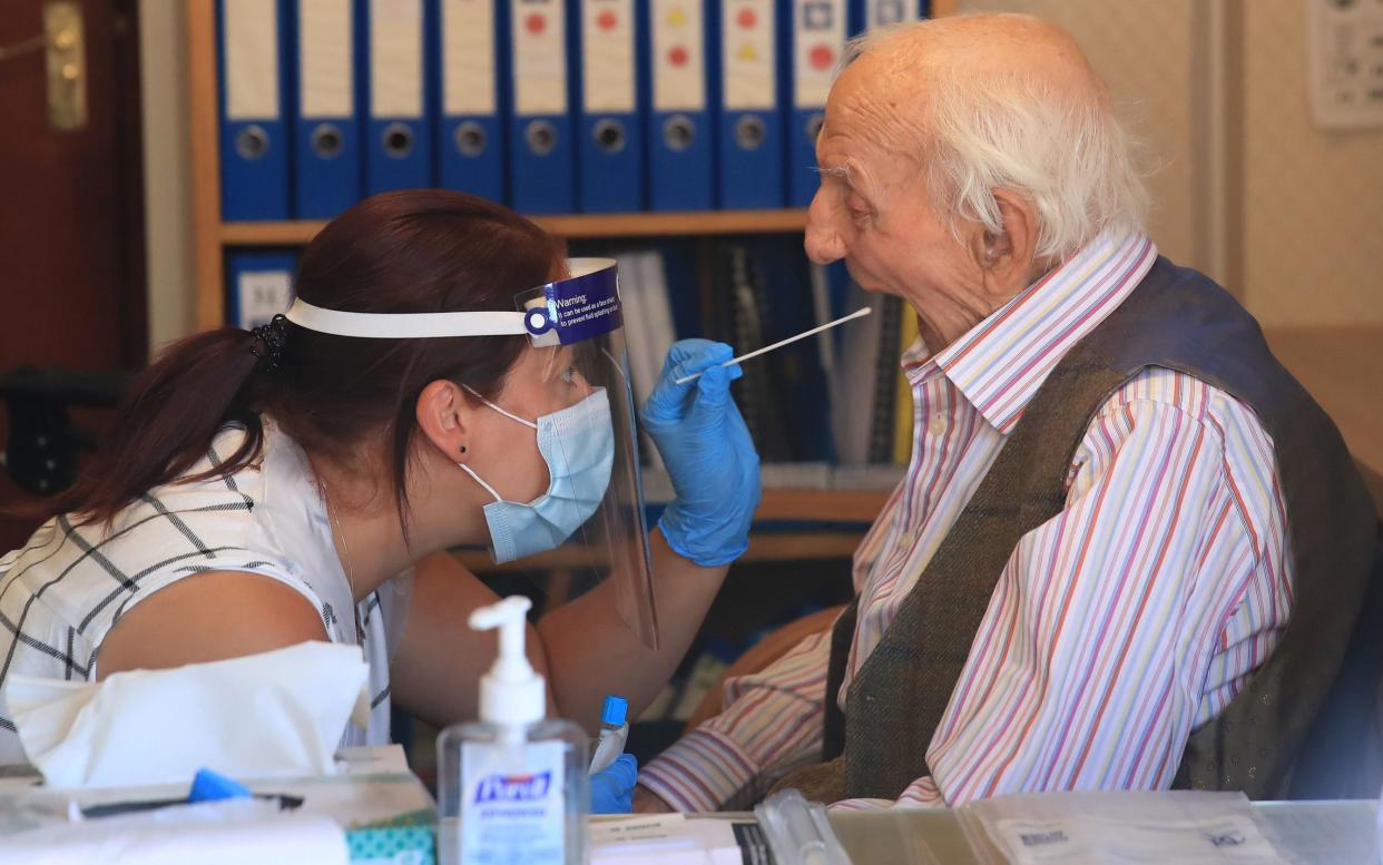 A care home assistant manager administers a coronavirus swab test at home in Whitley Bay, Tyneside - Owen Humphreys/PA