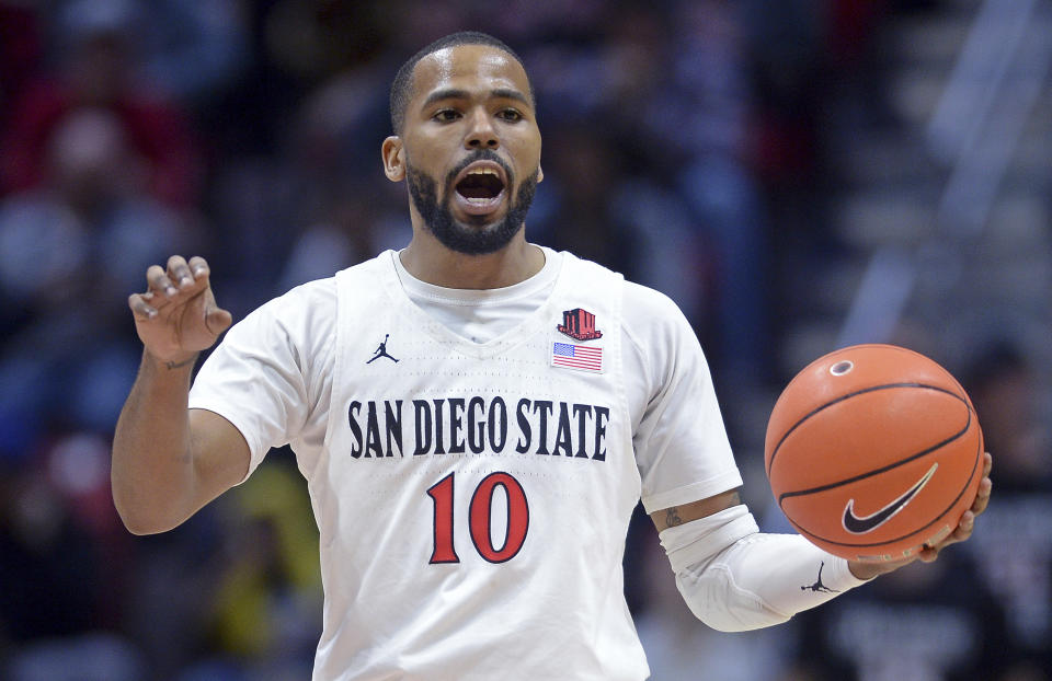 FILE - In this Dec. 28, 2019, file photo, San Diego State guard KJ Feagin gestures as he dribbles the ball during the second half of an NCAA college basketball game against Cal Poly in San Diego. It's almost like coach Brian Dutcher and the San Diego State Aztecs won the lottery. Tired of losing at their old schools, big man Yanni Wetzell and guards Malachi Flynn and Feagin transferred to San Diego State after being lured by the prospect of winning and going to the NCAA Tournament. And boy, have they ever won, to the point that they've matched some accomplishments by the breakthrough 2010-11 team led by the most famous player in program history, Kawhi Leonard. (AP Photo/Orlando Ramirez, File)