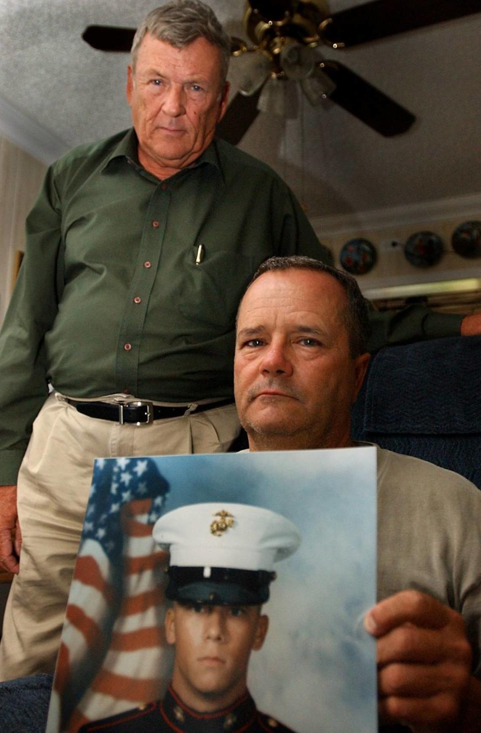 With his father, Cyril, at his side, Keith Dougherty, seated, holds a photo of his son, Lance Corporal Scott Dougherty of the United States Marine Corps Wednesday evening, July 7, 2004, in at their Manatee County home. Lance Cpl. Dougherty, a 2002 Bayshore High graduate, was killed in action in Iraq on that Tuesday.