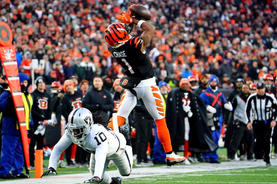 Cincinnati Bengals wide receiver Ja'Marr Chase (1) catches a pass as Las Vegas Raiders cornerback Desmond Trufant (10) defends in the second quarter during an NFL AFC wild-card playoff game, Saturday, Jan. 15, 2022, at Paul Brown Stadium in Cincinnati.