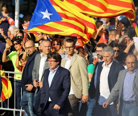 Catalan President Carles Puigdemont (L) arrives to a demonstration organised by Catalan pro-independence movements ANC (Catalan National Assembly) and Omnium Cutural, following the imprisonment of their two leaders Jordi Sanchez and Jordi Cuixart, in Barcelona, October 21, 2017. REUTERS/Ivan Alvarado