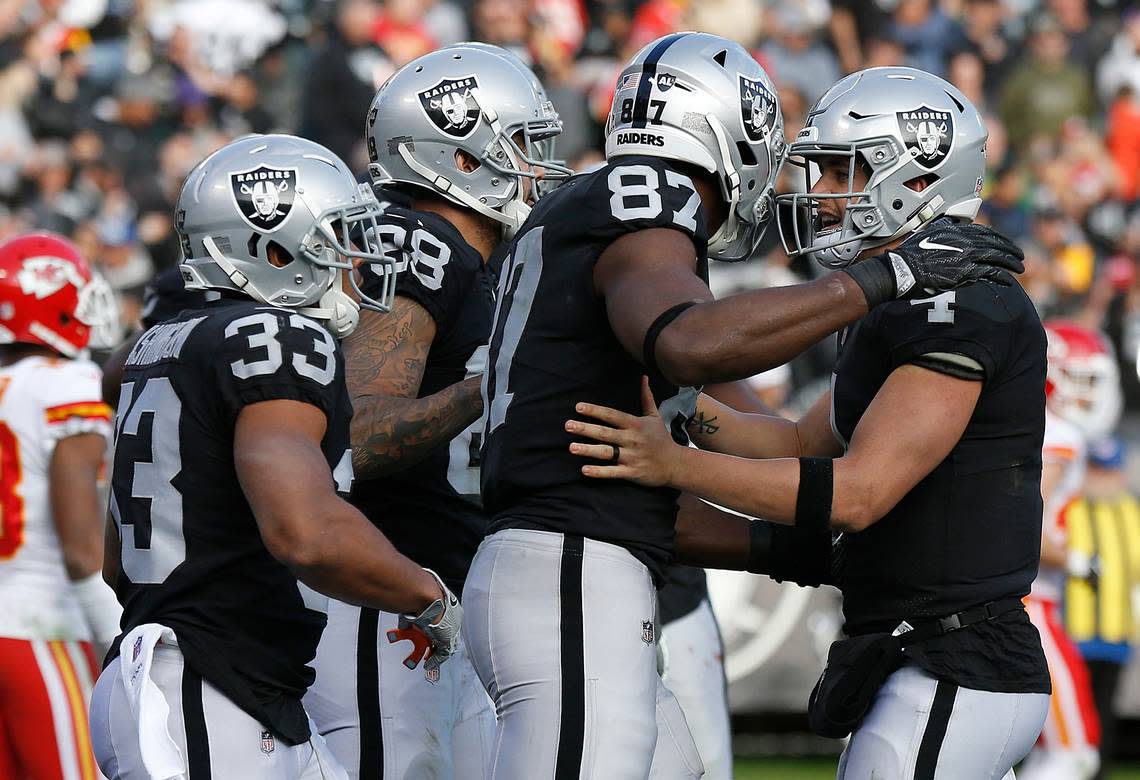 Derek Carr, right, celebrates with teammates after connecting on a touchdown pass against the Kansas City Chiefs during the second half of an NFL football game in Oakland, Calif., Sunday, Dec. 2, 2018.