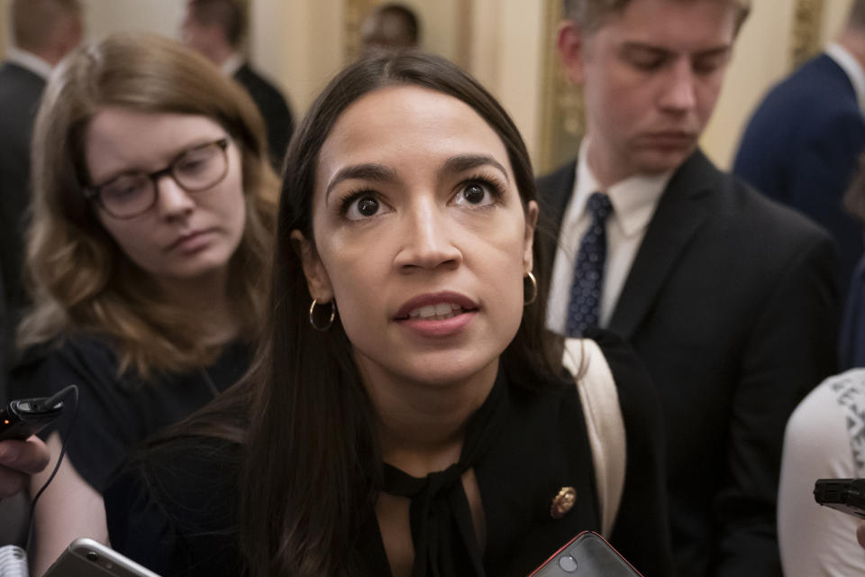 Rep. Alexandria Ocasio-Cortez, D-N.Y., a target of racist rhetoric from President Donald Trump, responds to reporters as she arrives for votes in the House, at the Capitol in Washington, Thursday, July 18, 2019. (AP Photo/J. Scott Applewhite)