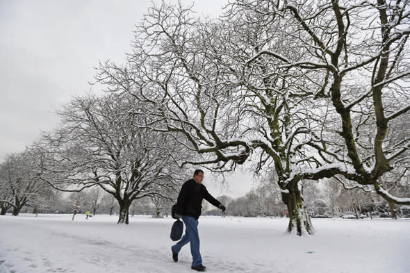 A man walks in a park, covered by snow in west London, Monday, Jan. 21, 2013. The big freeze across Britain is here to stay, with more heavy snow and falling temperatures forecast for Britain and Scotland. (AP Photo/Lefteris Pitarakis)