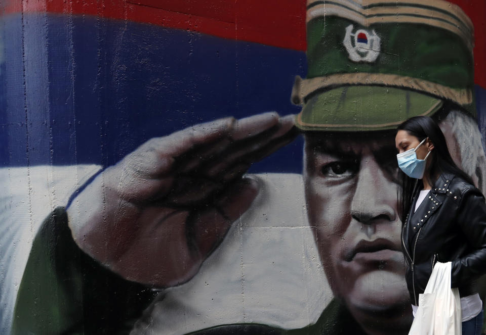 FILE — In this Thursday, Nov. 12, 2020 file photo, a woman wearing a mask against the spread of the coronavirus walks past a mural depicting former Bosnian Serb wartime general Ratko Mladic in Belgrade, Serbia. U.N. judges on Tuesday, June 8, 2021 deliver their final ruling on the conviction of former Bosnian Serb army chief Radko Mladic on charges of genocide, war crimes and crimes against humanity during Bosnia’s 1992-95 ethnic carnage. Nearly three decades after the end of Europe’s worst conflict since World War II that killed more than 100,000 people, a U.N. court is set to close the case of the Bosnian War’s most notorious figure. (AP Photo/Darko Vojinovic, File)