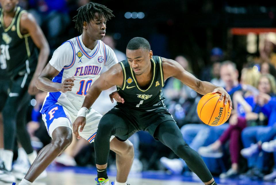 UCF Knights guard Jayhlon Young (1) tries to get by Florida Gators guard Denzel Aberdeen (10) during the second half of the NIT tournament Wednesday, March 15, 2023, at Exactech Arena in Gainesville, Fla. Florida lost to UCF 67-49. Alan Youngblood/Gainesville Sun