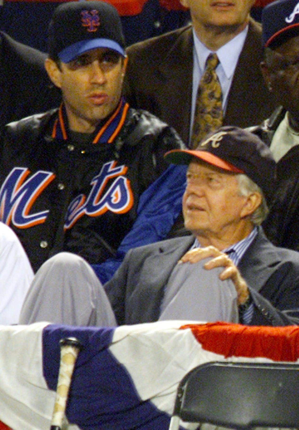 Jerry Seinfeld, left, and former President Jimmy Carter, right, watch the New York Mets and the Atlanta Braves play Game 6 of the National League Championship Series on Oct. 19, 1999, in Atlanta.