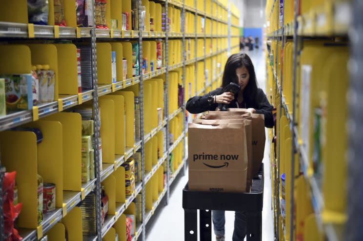 A staff member collects merchandise for customers' orders from shelves at the newly-opened Amazon Prime Now facility in Singapore Thursday, July 27, 2017. Amazon introduced express delivery in Singapore in its first direct effort to win over Southeast Asian digital natives and new internet users. The American e-commerce company announced Thursday it will begin operating a 100,000 square foot (9,290 square meter) distribution facility in the wealthy island nation. (AP Photo/Joseph Nair)