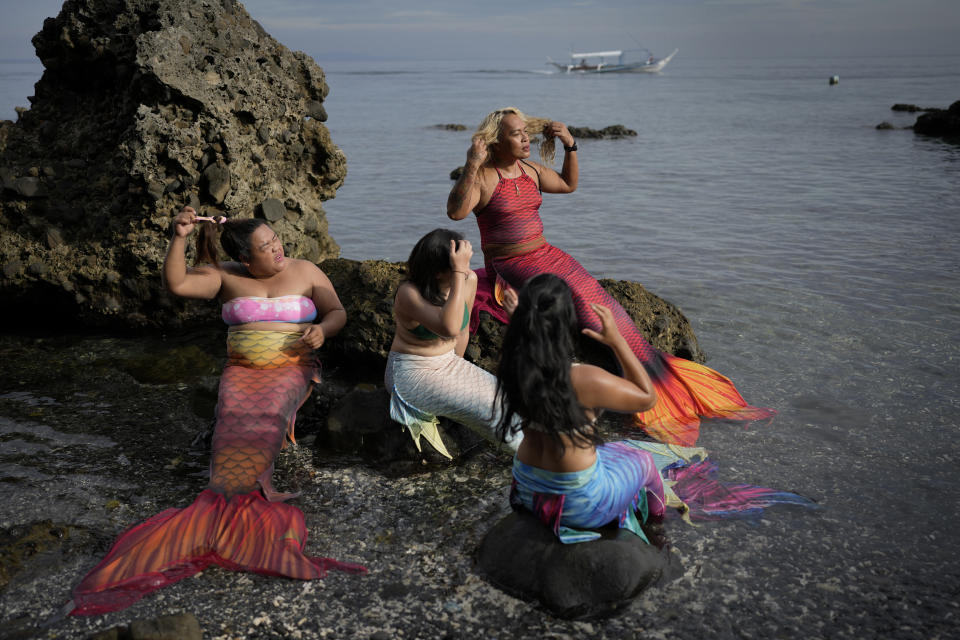 Queen Pangke Tabora (der) se prepara para dar una clase sobre cómo nadar como sirenas en Mabini (Filipinas) el 22 de mayo del 2022. (AP Photo/Aaron Favila)