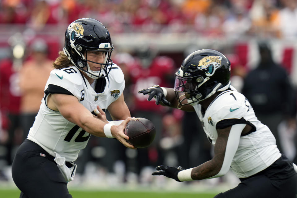 FILE - Jacksonville Jaguars quarterback Trevor Lawrence (16) hands off the ball to running back Travis Etienne Jr. (1) during the first half of an NFL football game against the Tampa Bay Buccaneers Sunday, Dec. 24, 2023, in Tampa, Fla. The Jacksonville Jaguars formally exercised fifth-year contract options Monday, April 29, 2024, on quarterback Trevor Lawrence and running back Travis Etienne.(AP Photo/Chris O'Meara, FIle)