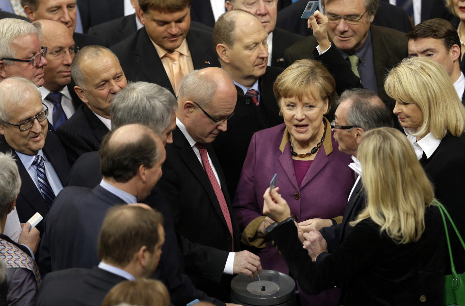 FILE - In this Nov. 30, 3012 file picture German Chancellor Angela Merkel casts her vote at the German federal parliament, Bundestag, in Berlin, Germany, Friday, Nov. 30, 2012. The German Parliament has given its overwhelming backing to a deal aimed at trimming Greece's debt load and keeping the country financially afloat. Lawmakers voted 473-100 on Friday to back the complex deal reached by European finance ministers earlier this week. Germany's chancellor says in an interview published saturday Dec. 1, 2012 she understands the frustration felt by many Germans over the repeated bailout programs for Greece. But Angela Merkel also insists that helping debt-ridden Greece is in her country's self-interest because it helps stabilize the 17-nation eurozone on which Germany's prosperity depends. (AP Photo/Michael Sohn,File)