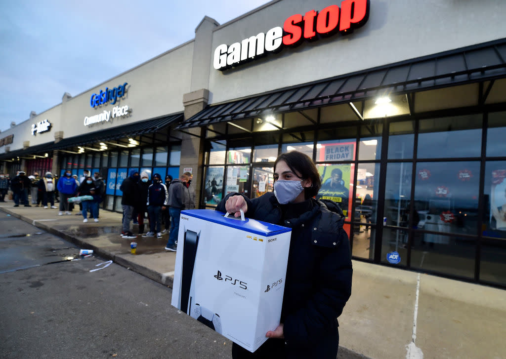 A man wearing a face masks leaves GameStop