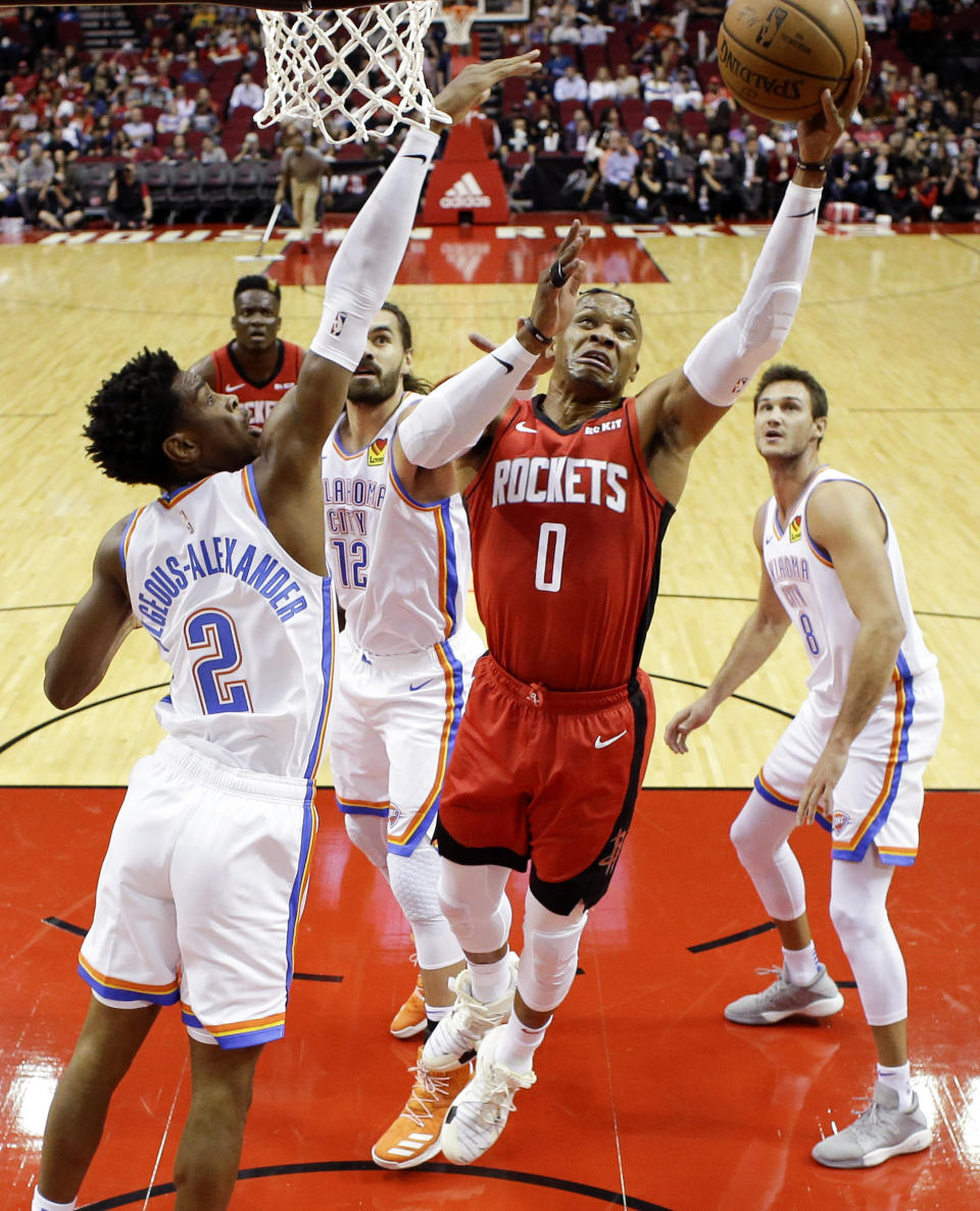 Houston Rockets guard Russell Westbrook (0) drives to the basket as Oklahoma City Thunder guard Shai Gilgeous-Alexander (2) defends during the first half of an NBA basketball game, Monday, Oct. 28, 2019, in Houston. (AP Photo/Eric Christian Smith)