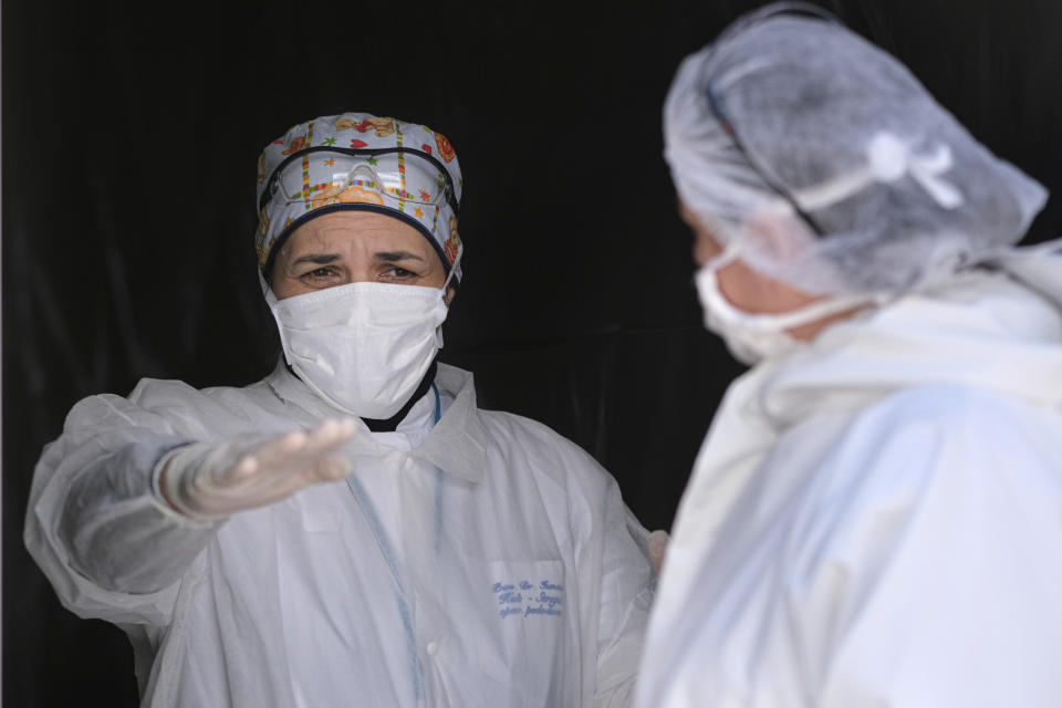 Medical staff gesture in the triage unit of the Vrazova community health center in Sarajevo, Bosnia, Tuesday, April 7, 2020. Less than three weeks ago, the respected Bosnian epidemiologist Sefik Pasagic was fielding calls from journalists seeking his opinion and advice on how best to prepare for the coronavirus outbreak. The 60-year-old father of four died of complications from the COVID-19 infection which his wife describes as an unnecessarily long and desperate struggle to get the help he needed.(AP Photo/Kemal Softic)