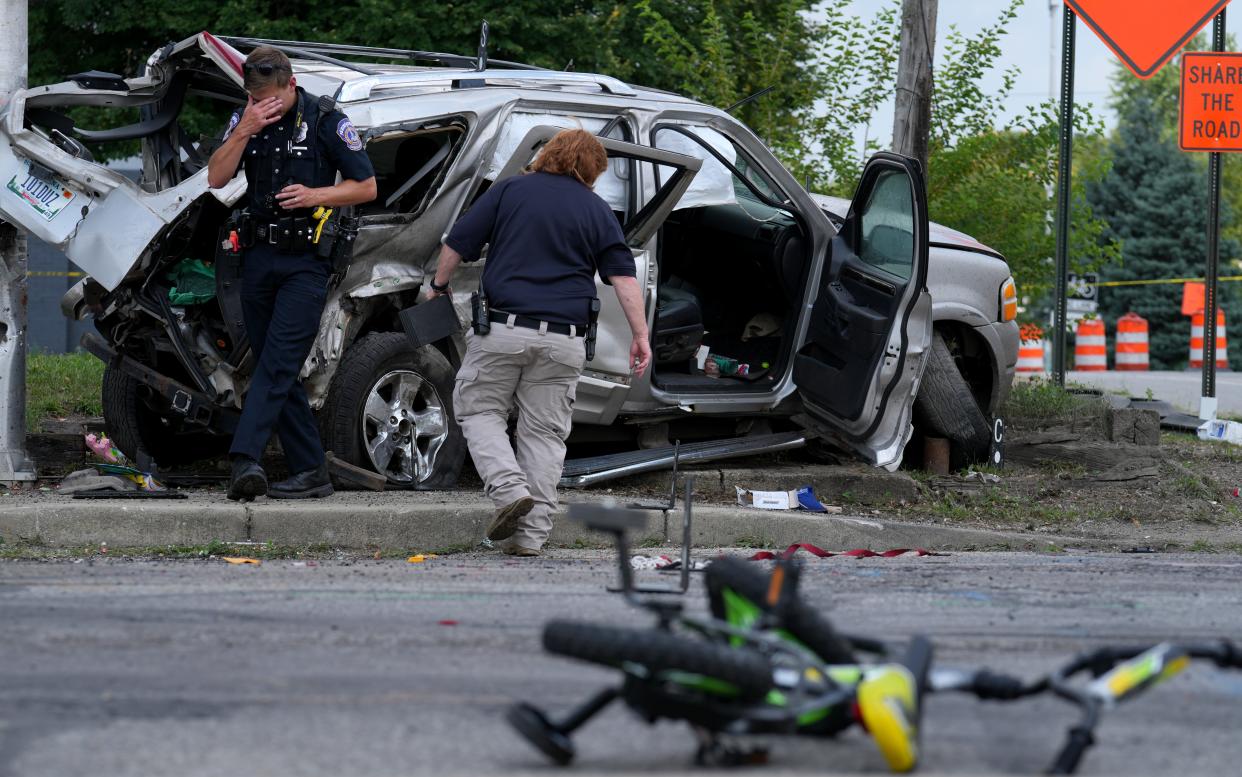 Law enforcement officials work the scene of an accident that officials say left left six kids and two adults injured on Tuesday, July 23, 2024, near the intersection of North State Avenue and East New York Street in Indianapolis.