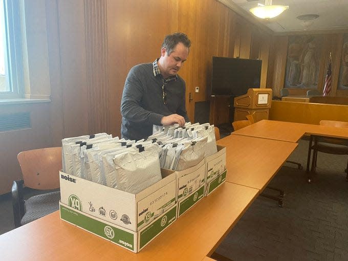 Emmett Reistroffer looks through 25 of the 26 applications he submitted for a medical marijuana dispensary license on Monday, Nov. 15.